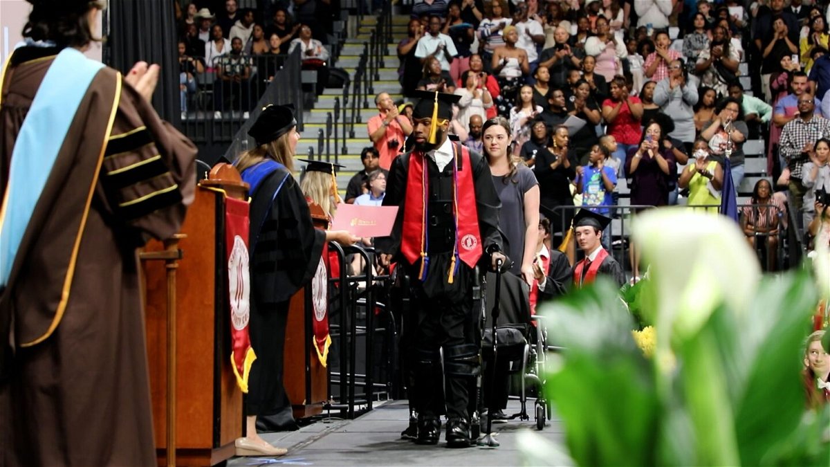 <i>Sheltering Arms Institute</i><br/>Khalil Watson uses an exoskeleton to stand and walk at his college graduation ceremony years after he was shot and paralyzed from the neck down.