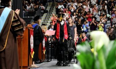 Khalil Watson uses an exoskeleton to stand and walk at his college graduation ceremony years after he was shot and paralyzed from the neck down.