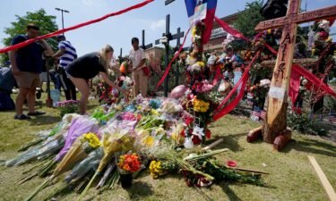 Mourners leave flowers at a makeshift memorial for the victims of the mass shooting in Allen