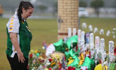 Santa Fe High School student Sierra Dean mourns the death of her friends killed in a recent shooting at a makeshift memorial left in their memory at Santa Fe High School in Santa Fe