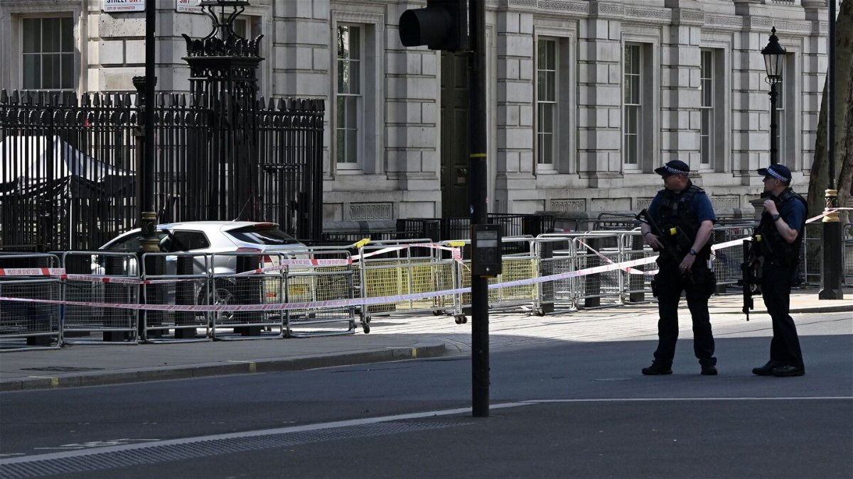 <i>Justin Tallis/AFP via Getty Images</i><br/>Police officers stand near the car that was driven into the gates of 10 Downing Street.