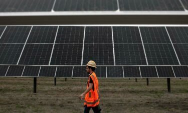 An ENGIE employee walks past solar panels at the ENGIE Sun Valley Solar project in Hill County
