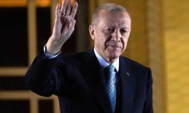 President Recep Tayyip Erdogan gestures to supporters at the presidential palace after winning the presidential runoff in Ankara