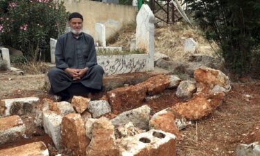 Mohammad Mesto sits next to the grave of his brother Lutfi