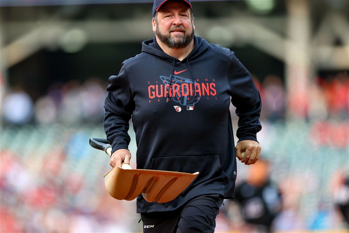 <i>Frank Jansky/Icon Sportswire/Getty Images</i><br/>A member of the Cleveland Guardians grounds crew leaves the field after collecting a bird that was struck and killed on the infield.