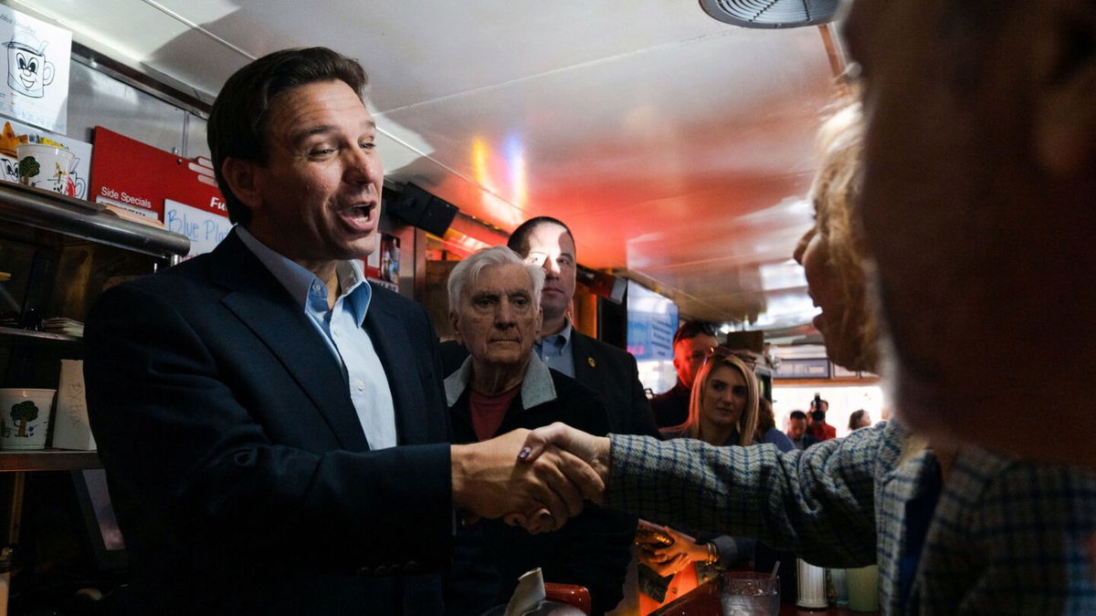 <i>Sophie Park/The New York Times/Redux</i><br/>Florida Gov. Ron DeSantis greets people at a diner in Manchester