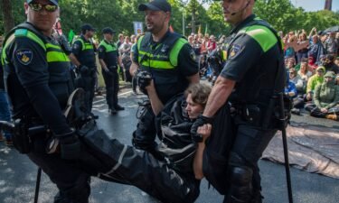 An activist is arrested after blocking the A12 motorway during an Extinction Rebellion led protest to command an end to all fossil fuel subsidies on May 27 in The Hague