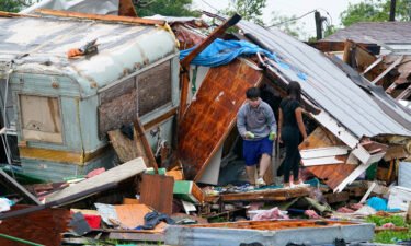 People salvage items from a home after a tornado hit Saturday