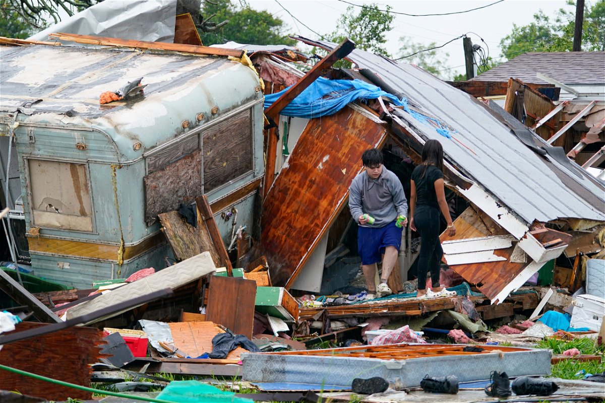<i>Julio Cortez/AP</i><br/>People salvage items from a home after a tornado hit Saturday