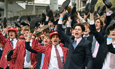 Eton schoolboys cheer on their team from the stands.