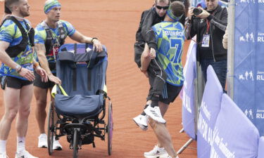 Sinfield carries Burrow across the finish line of the Rob Burrow Leeds Marathon at Headingley Stadium.