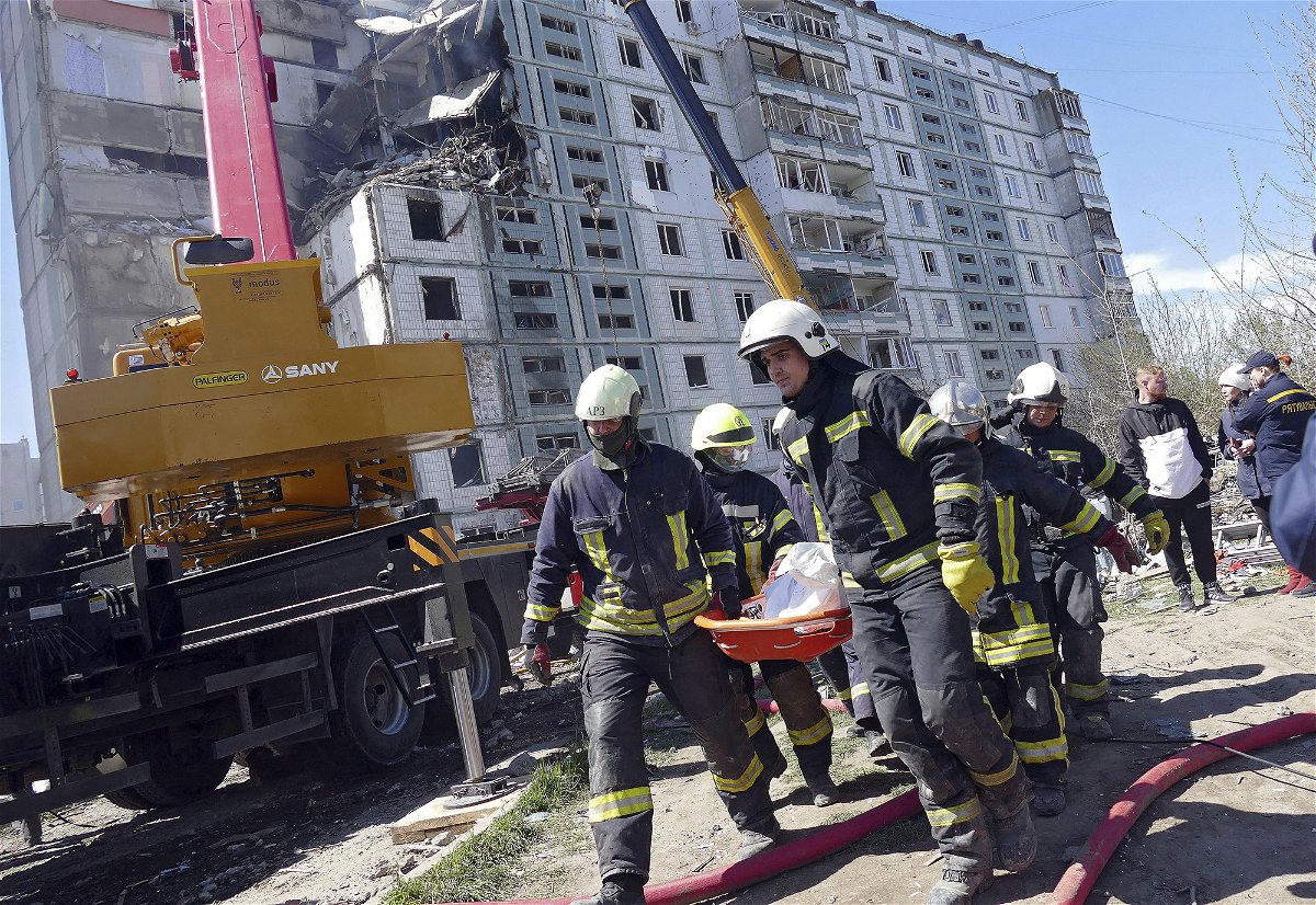 <i>Yulii Zozulia/Ukrinform/Abaca/Sipa USA/AP</i><br/>Rescuers carry the body of a victim found under the rubble at a block of flats destroyed in a Russian rocket attack on Uman