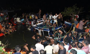 People attempt to rescue trapped tourists at the site of a boat accident in Tanur