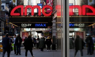 People make their way near an AMC Theatre on March 29 in New York City. Movie theater companies could be hurt most by the Writers Guild of America strike.