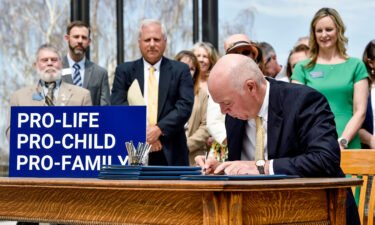 Gov. Greg Gianforte signs a suite of bills aimed at restricting access to abortion during a bill signing ceremony on the steps of the State Capitol