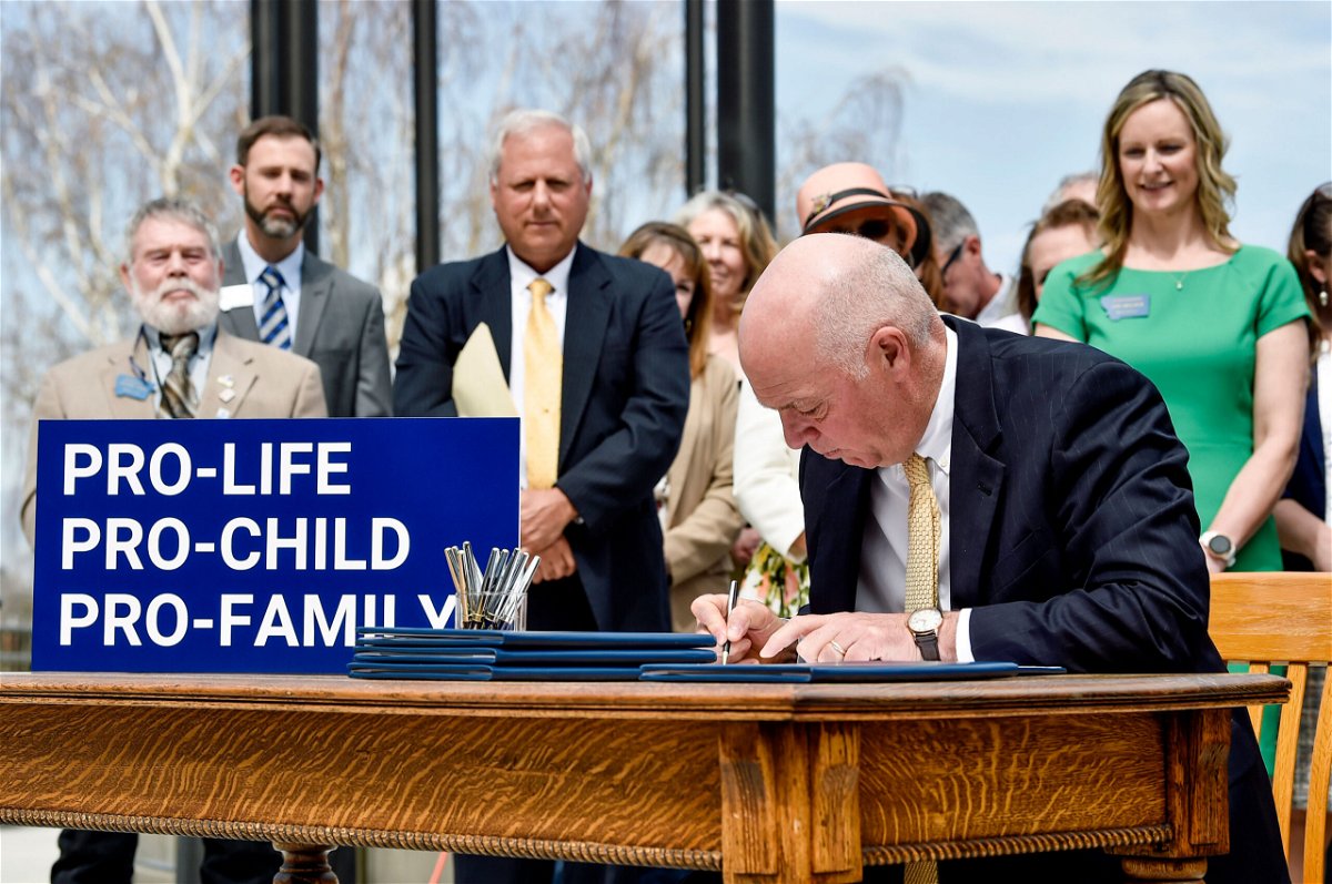 <i>Thom Bridge/Independent Record/AP</i><br/>Gov. Greg Gianforte signs a suite of bills aimed at restricting access to abortion during a bill signing ceremony on the steps of the State Capitol