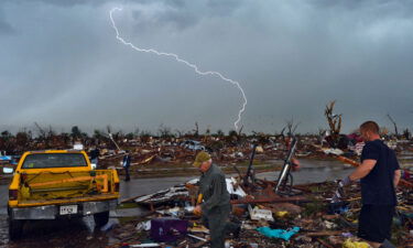 Lightning strikes as tornado survivors search for items at their devastated home on May 23