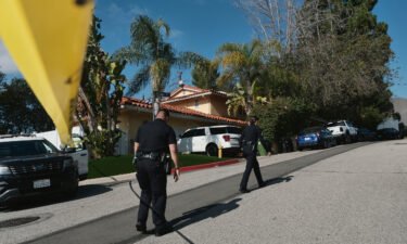 Police officers block the street access to a house where three people were killed and four others wounded in a shooting at a short-term rental home in an upscale neighborhood in Los Angeles on January 28.