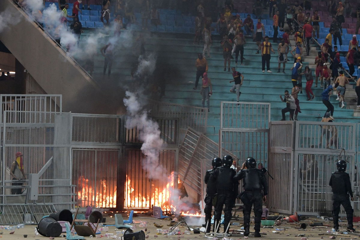 <i>Fethi Belaid/AFP/Getty Images</i><br/>Esperance supporters clash with riot police during the CAF Champions League quarterfinal match between Esperance Sportive de Tunis and JS Kabylie.