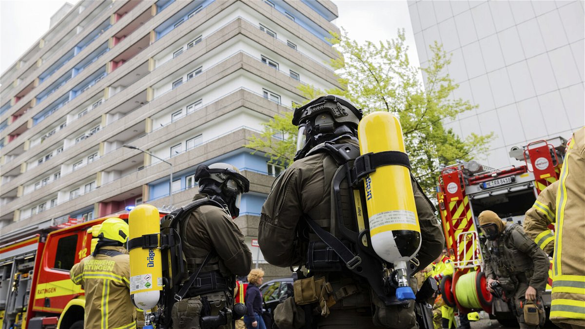 <i>Rolf Vennenbernd/dpa/AP</i><br/>Police officers with gas masks and firefighters gather in front of the building.