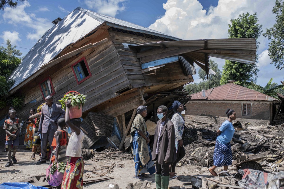 <i>Moses Sawasawa/AP</i><br/>People walk next to a house destroyed by the floods in the village of Nyamukubi