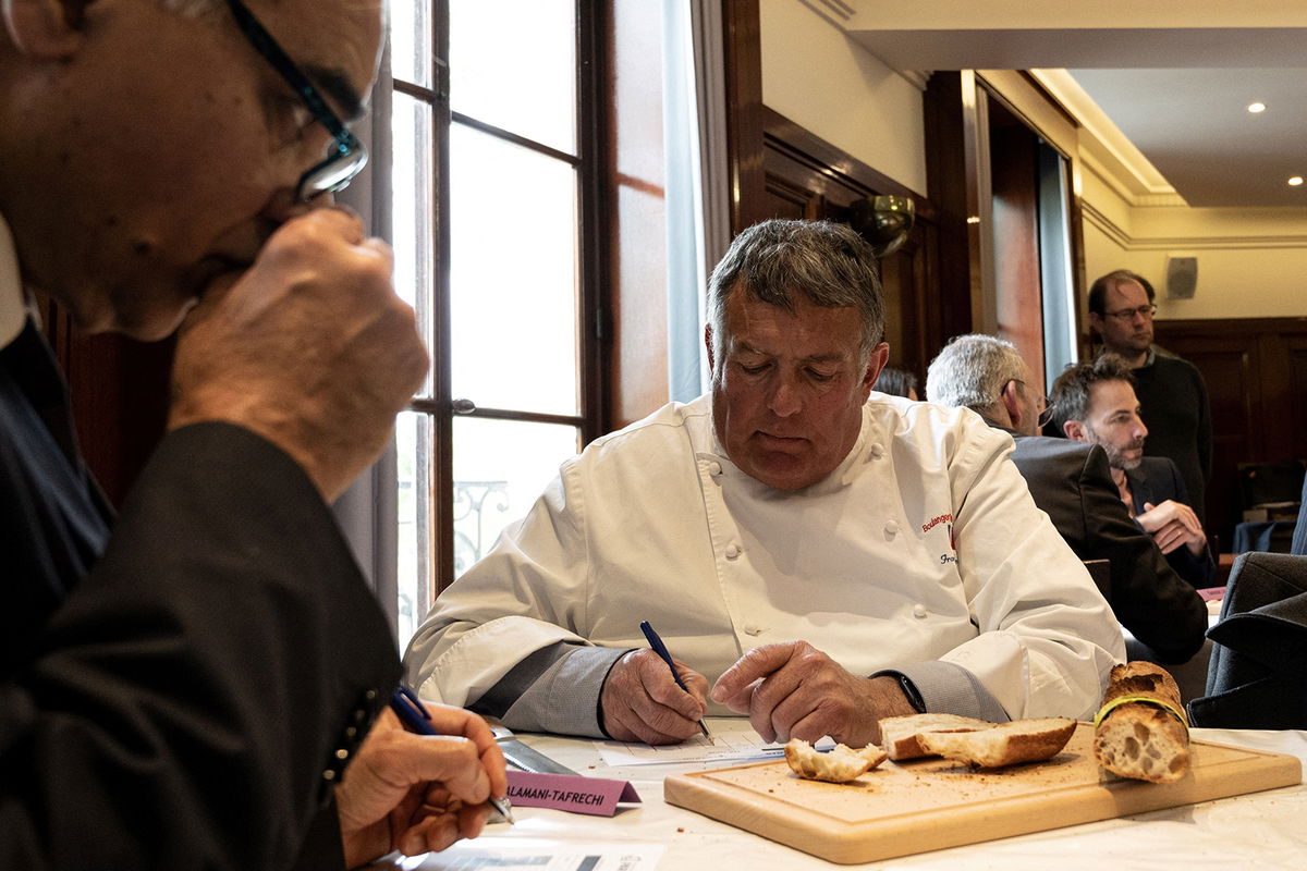 <i>Alain Jocard/AFP/Getty Images</i><br/>A member of the jury inspects baguettes for the 2023 contest.