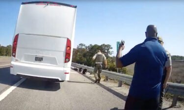 A still from body camera footage released by the Liberty County Sheriff's Office shows the bus and driver on the side of the highway.