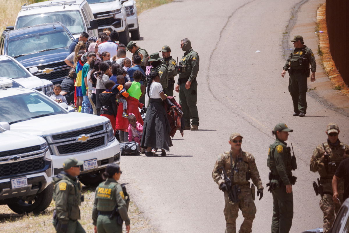 <i>Mike Blake/Reuters</i><br/>US border patrol personnel organize a group of families near San Diego