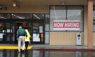 The number of open jobs in the United States has dropped to the lowest level since May 2021. People walk by a now hiring sign posted in front of a CVS store on April 07