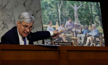 Senate Judiciary Committee member Sen. Sheldon Whitehouse (D-RI) displays a photo featuring Supreme Court Justice Clarence Thomas alongside other conservative leaders during a hearing on Supreme Court ethics reform on Capitol Hill on May 02