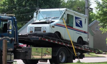 A USPS mail truck flips to its side in Waukesha