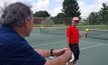 An attendee of a veteran pickleball clinic grins at his fellow vet before serving. John Beaudry