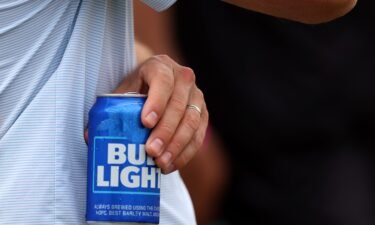 A fan holds a Bud Light beer during day three of the LIV Golf Invitational - DC at Trump National Golf Club on May 28