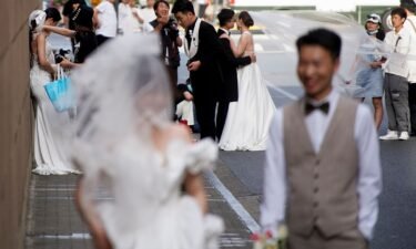 Couples prepare to get their photo taken during a wedding photography shoot on a street in Shanghai in 2021.