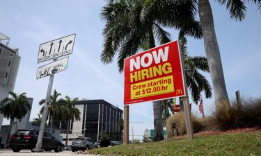 A 'Now Hiring' sign posted outside of a restaurant looking to hire workers on May 05