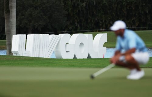 Signage is seen as Charl Schwartzel of Stinger GC lines up a putt on the fourth green during the team championship stroke-play round of the LIV Golf Invitational - Miami at Trump National Doral Miami on October 30