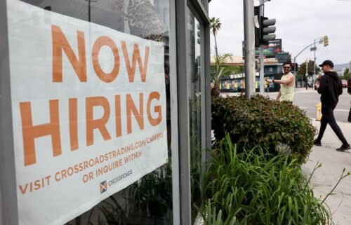 A 'Now Hiring' sign is displayed outside a resale clothing shop on Friday in Los Angeles