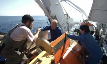 MIR crew members help James Cameron (center) into MIR 1 during the filming of Cameron's documentary "Ghosts of the Abyss" (2003).