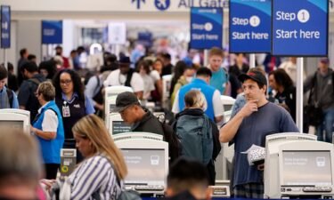 Travelers wait in line at the departure area check-in at the United Airlines terminal at Los Angeles International airport