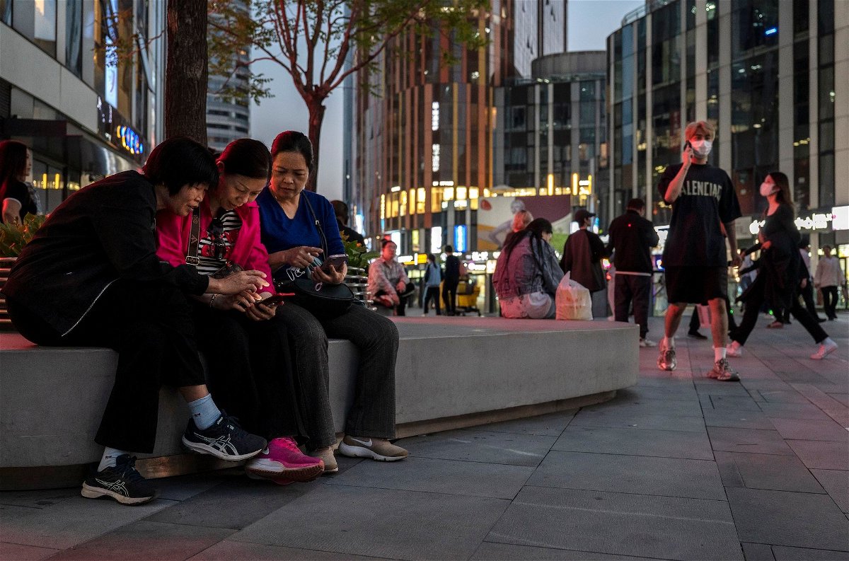 <i>Kevin Frayer/Getty Images</i><br/>Women watch a video on a mobile phone in a busy retail shopping area in Beijing