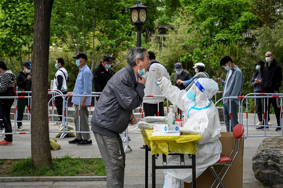 <i>Jade Gao/AFP/Getty Images/File</i><br/>A health worker tests a man for Covid-19 in Beijing last year.