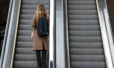 An office worker rides an escalator at London Bridge railway station in London