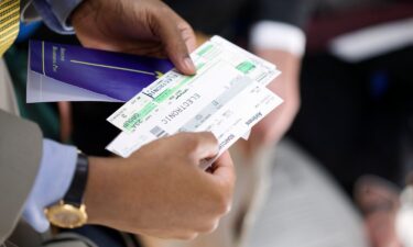 A man holds a paper boarding pass