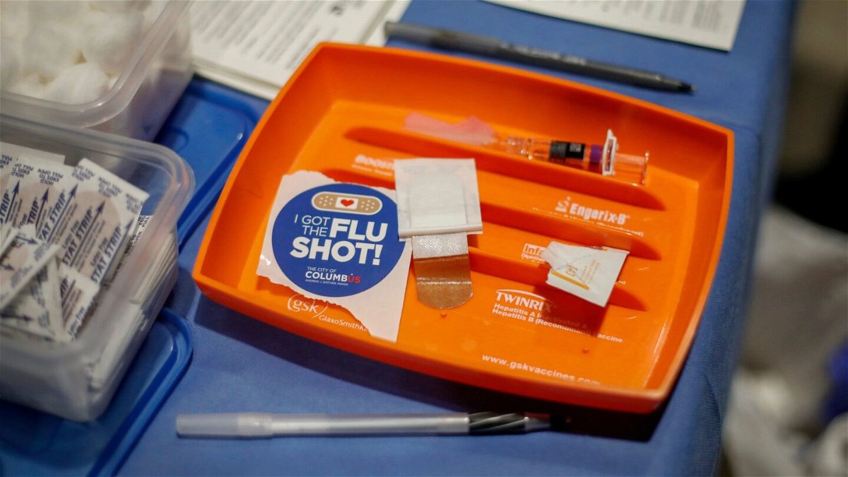 <i>Adam Cairns/Columbus Dispatch/USA Today Network</i><br/>A shot and sticker await those in the free flu shot drive through line in Columbus