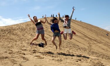 Japanese women prance on Tottori sand dunes in 2012 in Tottori