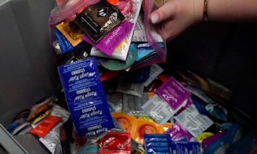 A sexual health peer educator at the University of Oklahoma dumps condoms into a container at the health center on campus in May.