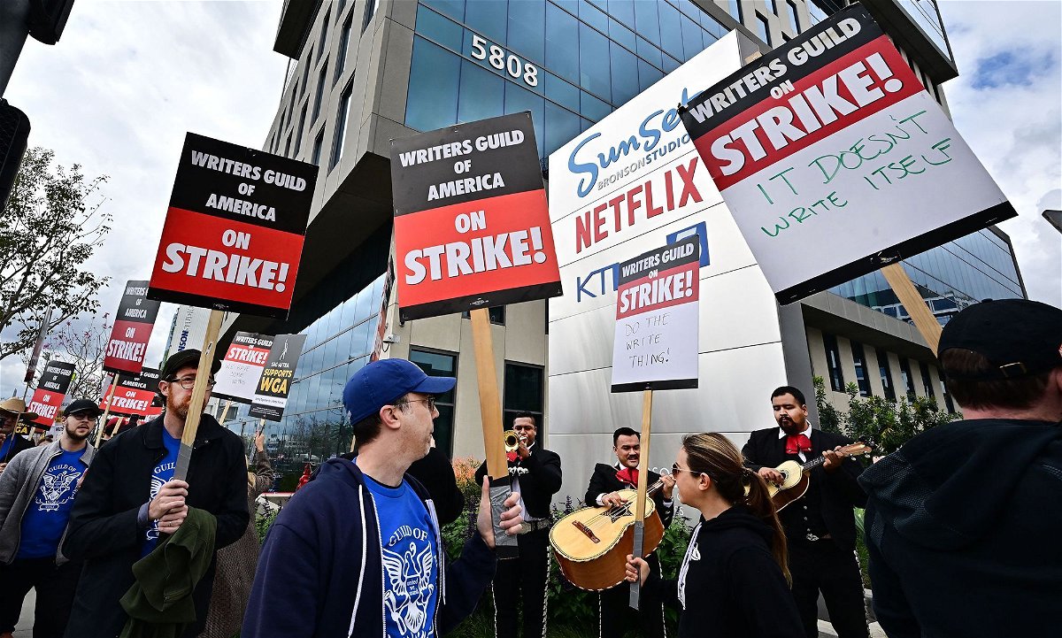 <i>Frederic J. Brown/AFP/Getty Images</i><br/>Writers on strike march with signs on the picket line on day four of the strike by the Writers Guild of America in front of Netflix in Hollywood