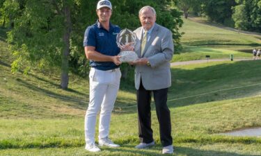 Hovland and Jack Nicklaus pose with the Memorial Tournament trophy.