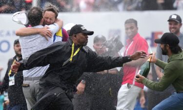 A security guard stops Hadwin as Taylor celebrates.