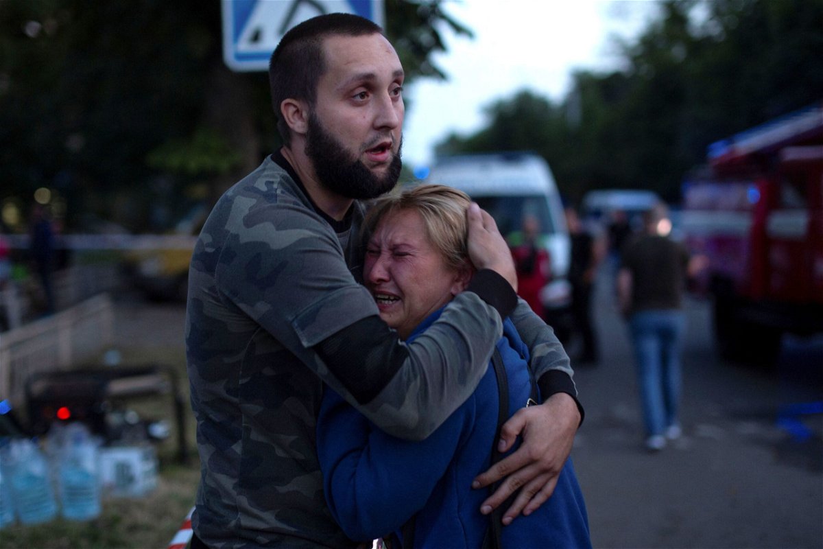 <i>Oleksandr Ratushniak/Reuters</i><br/>People comfort each other at the site of a Russian missile strike in Kramatorsk on June 27.